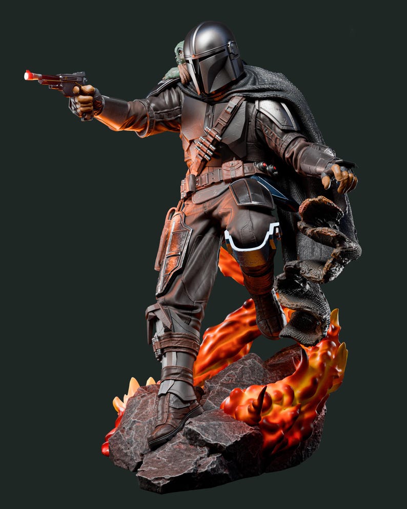 May include: A detailed figurine of a character in dark armour, holding a blaster pistol with a red light. The figure is posed on a rocky base with fiery orange and yellow accents. A cape and helmet complete the look.