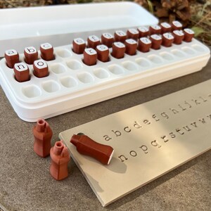 Alphabet letter stamps for impressions in clay or soap making.  Holder box with lid.