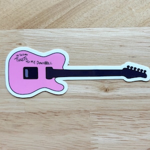 May include: Pink electric guitar sticker with black details. The sticker says "I'm selling tickets to my downfall."