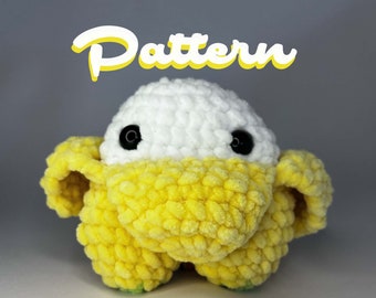 May include: A crocheted plush toy with a white head and yellow body. The toy has black eyes and a small, rounded nose.