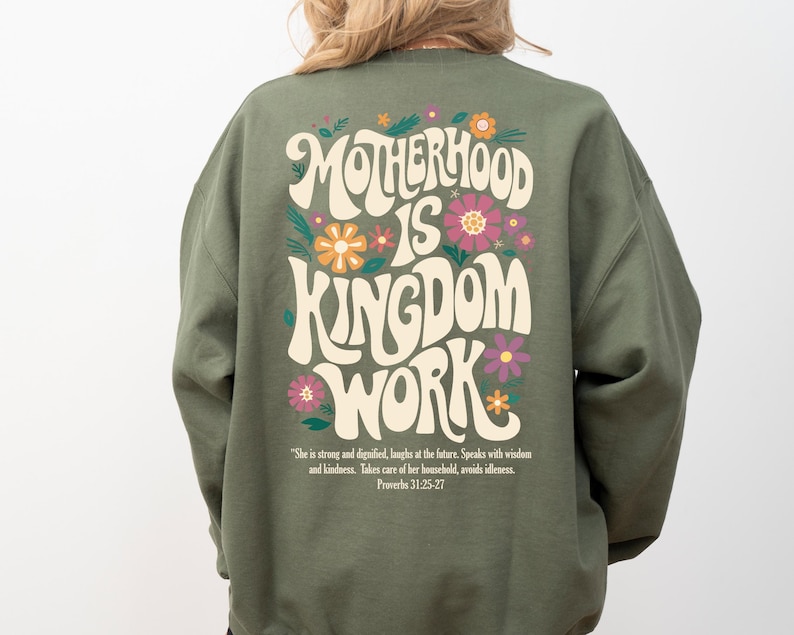 May include: Green sweatshirt with a retro-style graphic that says "Motherhood is Kingdom Work" with flowers and a quote from Proverbs 31:25-27.