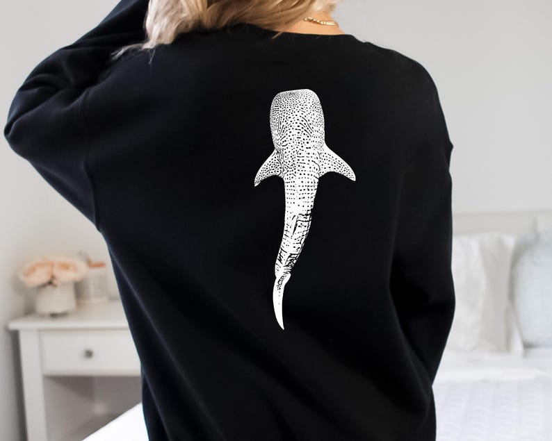 May include: Black sweatshirt with a white whale shark graphic on the back.