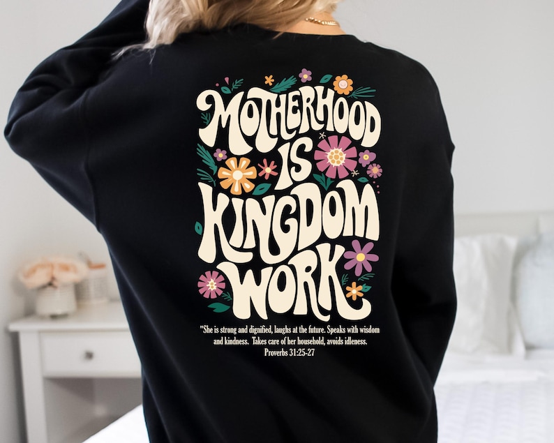 May include: Black sweatshirt with a floral design and the text "Motherhood is Kingdom Work" in a retro font. The text is accompanied by a quote from Proverbs 31:25-27.