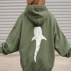 May include: A green hooded sweatshirt with a white whale shark graphic on the back.
