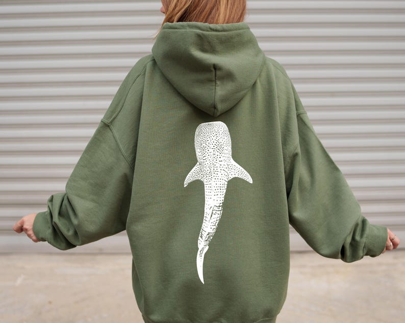 May include: A green hooded sweatshirt with a white whale shark graphic on the back.