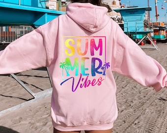Puede incluir: Sudadera rosa con un gráfico de arcoíris que dice "Summer Vibes" en la espalda. El gráfico también incluye palmeras.