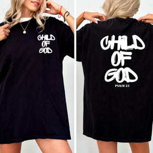 May include: Black t-shirt with the text "CHILD OF GOD" in white on the front and back. The back of the shirt also includes "PSALM 23" in white. The shirt has a crew neck and short sleeves.