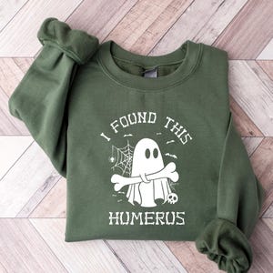 May include: A green sweatshirt with a white ghost graphic and the text "I found this humerus".