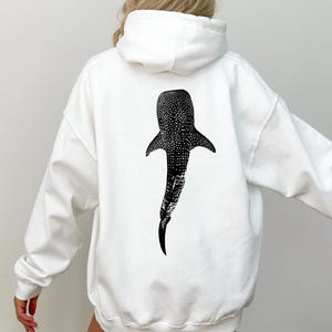 May include: White hoodie with a black and white whale shark graphic on the back.