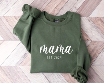 May include: A dark green sweatshirt with the text "mama est 2024" in white.