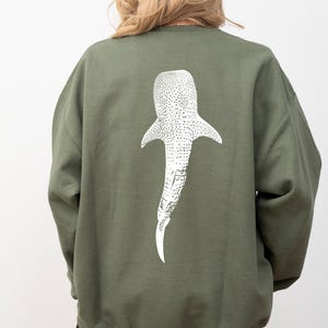 May include: A green sweatshirt with a white whale shark graphic on the back.