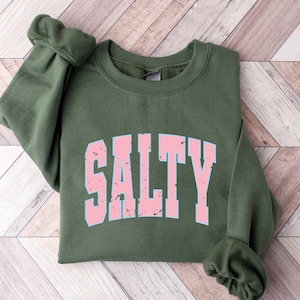 May include: A green sweatshirt with the word "SALTY" printed in pink letters with a distressed look.