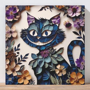 May include: Square canvas art featuring a smiling blue cat with purple ears and a long tail, surrounded by colorful paper flowers. The cat has a wide grin and is set against a cream background. The artwork is displayed on a wooden surface.