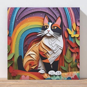 May include: A colorful cat art print featuring a calico cat with orange, black, and white fur, set against a rainbow and floral background. The artwork is displayed on a wooden surface.