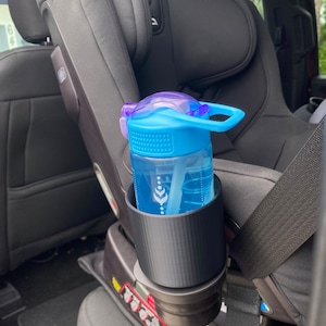 May include: A black car seat cup holder with a blue and purple water bottle inside. The cup holder is attached to the side of the car seat.
