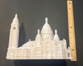 May include: White 3D printed model of the Sacré-Cœur Basilica in Paris, France. The model is approximately 6 inches tall and features intricate details of the church's architecture.