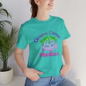 Terra - Centro - Maglietta Manifest: Maglietta con disegno di fiori di loto dipinti a mano - Design di meditazione per i buoni propositi per l'anno nuovo in verde, verde acqua e lilla