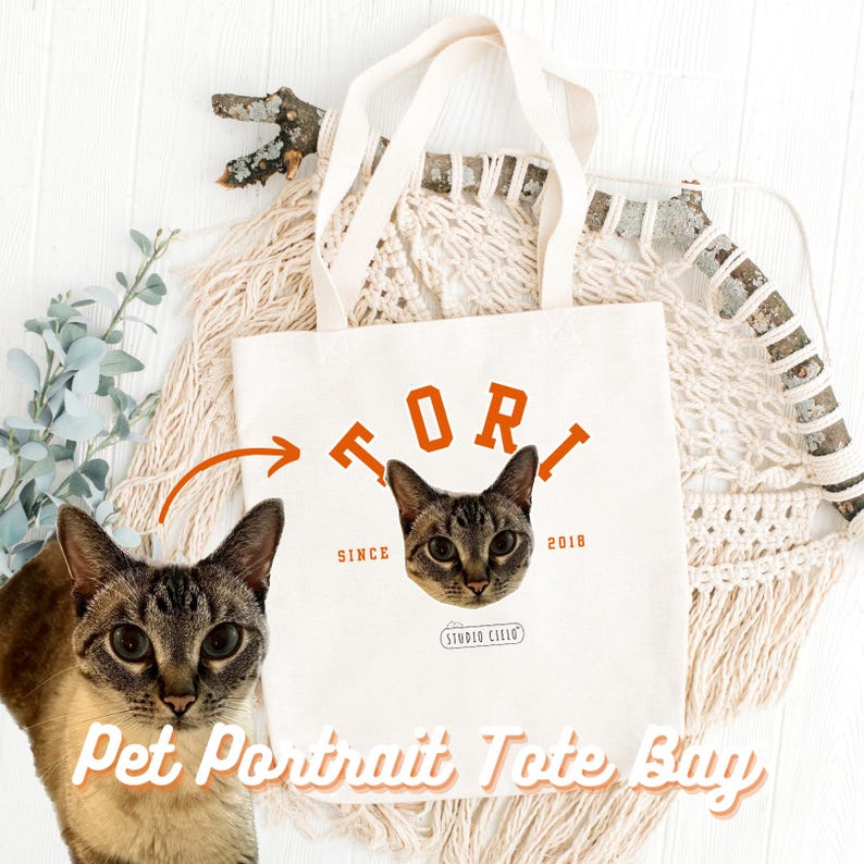 May include: White canvas tote bag with a cat portrait and the text "TORI SINCE 2018" in orange. The text "Pet Portrait Tote Bag" is printed in orange at the bottom of the bag.