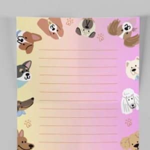 May include: A lined notepad with a gradient background of yellow and pink. The notepad is decorated with cartoon dog faces around the edges and paw prints. The notepad is blank and ready for notes.