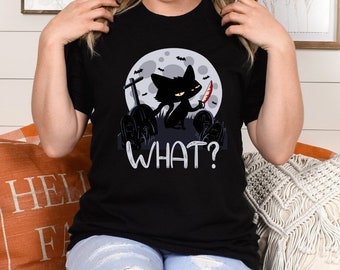 May include: A black t-shirt with a graphic of a black cat holding a knife in front of a full moon and the words "WHAT?" printed on the front.