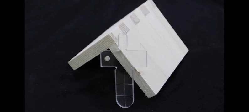 Pu&ograve; includere: Una staffa d'angolo bianca con una staffa d'angolo in plastica trasparente fissata ad essa. La staffa d'angolo &egrave; progettata per aiutare a sostenere e rinforzare un giunto d'angolo.