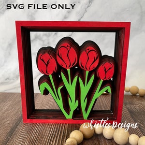 Könnte beinhalten: Rote und grüne, mehrschichtige Papierkunst mit Tulpen in einem roten Rahmen. Das Design trägt den Titel "Whistles Designs".