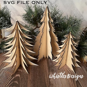 May include: Three wooden Christmas tree cutouts in various sizes. The trees are made of light brown wood and have a simple, rustic design. The trees are arranged on a wooden surface.