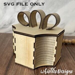 May include: A wooden box with a hexagonal top and sides, featuring decorative arched accents. The box is made of light-colored wood with etched details. The text "SVG FILE ONLY" is at the top, and "Whistles Designs" is at the bottom.