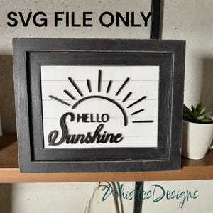 May include: A framed wooden sign with the words "HELLO Sunshine" in a black, stylized font. The sign features a sun design with rays. The background is white with horizontal lines, and the frame is dark gray. The text "SVG FILE ONLY" is at the top.