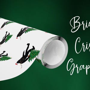 Puede incluir: Un rollo de papel de regalo blanco con un patr&oacute;n repetitivo de siluetas negras de Bigfoot cargando &aacute;rboles de Navidad verdes con detalles rojos. El texto Bright Crisp Graphics aparece en letra blanca a la derecha.