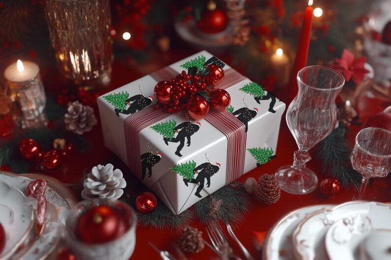 Puede incluir: Una caja de regalo cuadrada envuelta en papel blanco con un patr&oacute;n repetitivo de siluetas negras de una criatura cargando un &aacute;rbol de Navidad verde. La caja est&aacute; atada con una cinta a rayas rojas y blancas y decorada con adornos rojos.