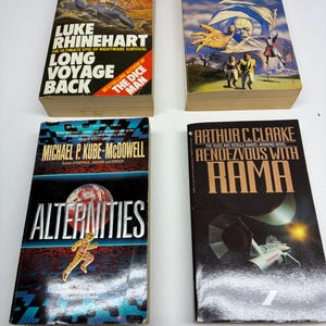 May include: Four science fiction paperback books arranged in a grid. The titles are Long Voyage Back by Luke Rhinehart, The Anubis Gates by Tim Powers, Alternities by Michael P. Kube-McDowell, and Rendezvous with Rama by Arthur C. Clarke.