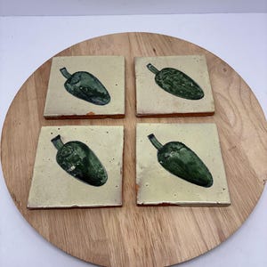 May include: A white ceramic mug with a black handle and the text "But First, Coffee" in a bold, black font. The mug is set against a blurred background, suggesting a cozy setting. The mug appears to be approximately 4 inches tall.