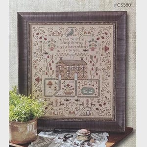May include: A framed cross-stitch sampler featuring a house, floral motifs, birds, and the alphabet, with the text 'Be you to others kind & true as you have others be to you' and '2025'. Below, a circular logo reads 'STAY TRUE design by Brenda Gervais'.