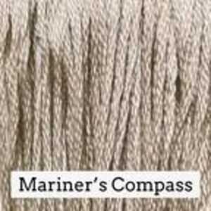 May include: A bundle of light beige embroidery thread with a vertical, fibrous texture. At the bottom, a white rectangular label features the black printed text Mariner's Compass, clearly identifying the specific color name of the thread.