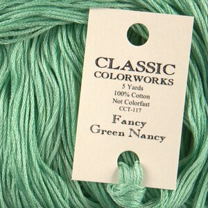 May include: A skein of light green embroidery floss with a label that reads "CLASSIC COLORWORKS 5 Yards 100% Cotton Not Colorfast CCT-117 Fancy Green Nancy"