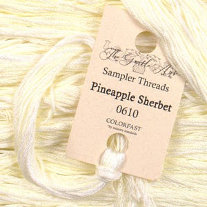 May include: A skein of pale yellow embroidery floss with a label that reads "The Gentle Art Sampler Threads Pineapple Sherbet 0610 COLORFAST by industry standards".