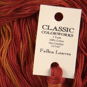 May include: A skein of red and orange embroidery floss with a label that reads "Classic Colorworks, 5 Yards, 100% Cotton, Not Colorfast, CCT-067, Fallen Leaves".