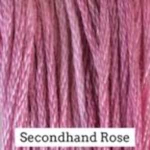 May include: A collection of vertical strands of embroidery floss in a dusty pink hue. A white rectangular label is positioned at the bottom center of the image with the black printed text Secondhand Rose clearly visible on the white background.