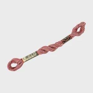 May include: A skein of dusty rose embroidery floss featuring a twisted, multi-strand construction. The thread is secured with two paper labels, one of which displays a barcode and the number 223, while the other features the DMC brand logo.