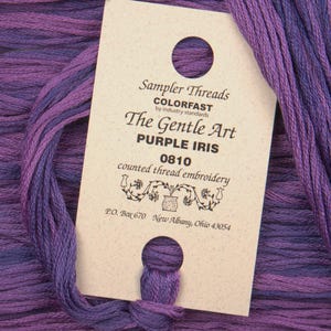 May include: A skein of purple embroidery floss with a label that reads "Sampler Threads Colorfast by industry standards The Gentle Art Purple Iris 0810 counted thread embroidery P.O. Box 670 New Albany, Ohio 43054"