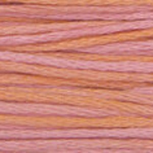 May include: A close-up of a spool of pink and orange yarn. The yarn is soft and textured, and it is perfect for knitting or crocheting.