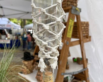Glass bottle planter with macramé holder