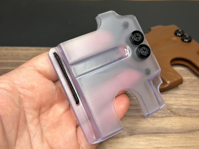 Puede incluir: Un porta tarjetas de pl&aacute;stico transparente con una banda el&aacute;stica negra y dos tornillos negros. El porta tarjetas tiene una ranura para tarjetas y un peque&ntilde;o agujero para un cord&oacute;n.