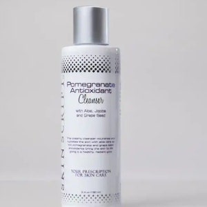 May include: A white bottle of Pomegranate Antioxidant Cleanser with a silver lid. The bottle has a black and white polka dot pattern and the text "Pomegranate Antioxidant Cleanser" is printed in black. The text "with Aloe, Jojobe and Grape Seed" is printed in black below the product name. The text "YOUR PRESCRIPTION FOR SKIN CARE" is printed in black at the bottom of the bottle.