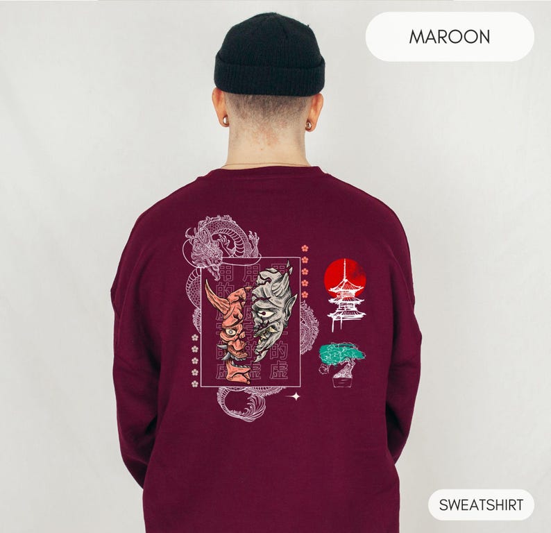 May include: Maroon sweatshirt with a white graphic print of a dragon, a Japanese temple, a bonsai tree, and two masks. The text "MAROON" is in the top right corner and "SWEATSHIRT" is in the bottom right corner.