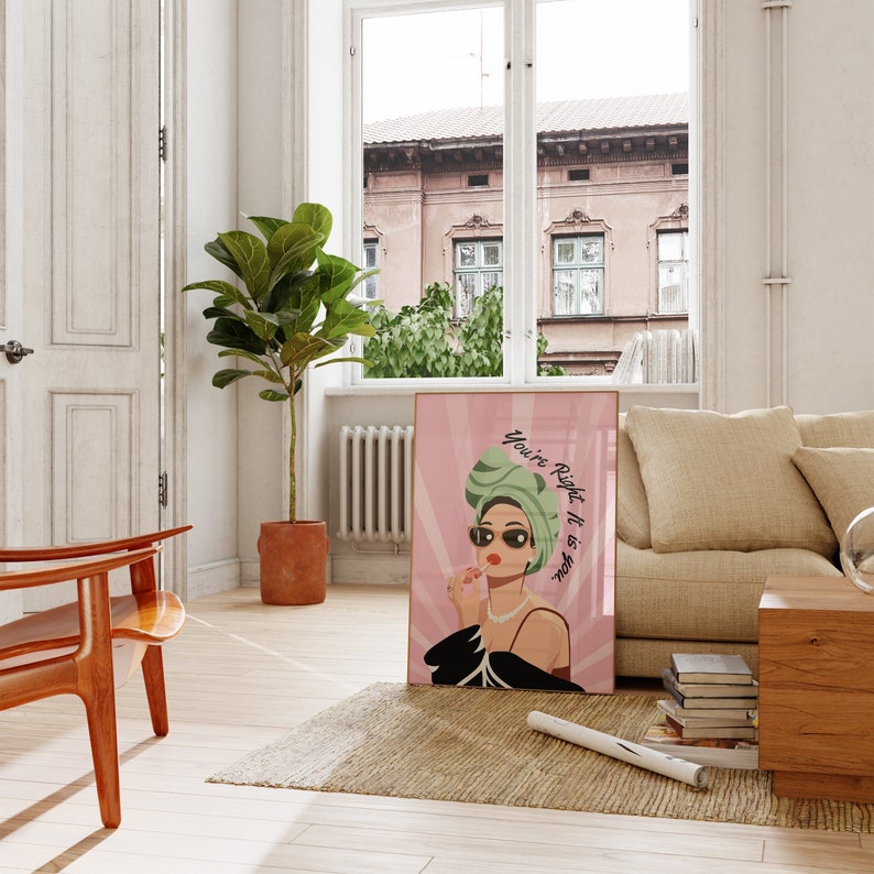 May include: A pink and white poster with a woman wearing a green turban and sunglasses. The text on the poster reads "You're Right, It Is About You."