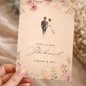 Karte zur Hochzeit mit Namen und Datum in der Hand gehalten, eco friendly Graspapier Karte mit Aquarell Illustration Brautpaar