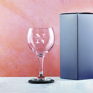 May include: A clear glass gin glass with a slate coaster. The glass has a single initial "N" etched on the front with the word "Name" underneath.