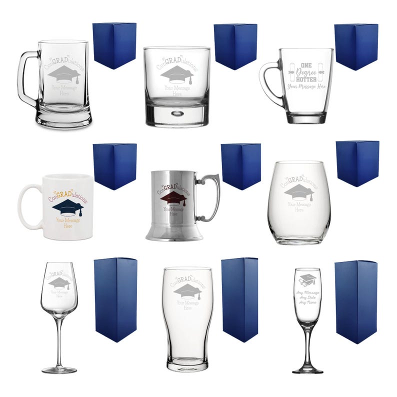 May include: An assortment of clear glass drinkware, including mugs, tumblers, and stemware, each etched with a graduation cap design and the word "Congrats". Each piece is paired with a navy blue gift box.